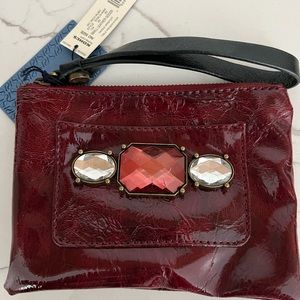 Vera Wang Vintage Faux Patent Leather wristlet. The color is burgundy.